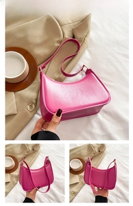 Close-up of rose red crescent shoulder bag with golden hardware and adjustable strap