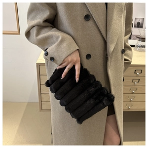 Détail de pochette en fausse fourrure noire avec rayures horizontales et texture douce