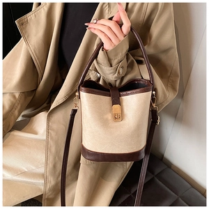 Detail of vintage textured bucket bag featuring a gold metal buckle and leather handle