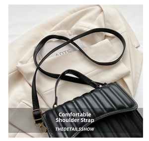 Detail der schwarzen Stepptasche mit vertikalen Nähten und verstellbarem Schultergurt