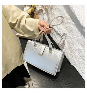 Detailsicht der silbernen Metallic-Handtasche im quadratischen Design mit Tragegriff