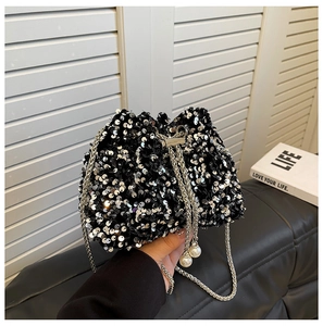 Detail of silver sequins on a black bucket bag with pearl drawstring and chain strap