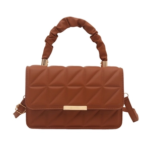 Brown quilted crossbody bag with scrunchie handle and gold clasp on white background