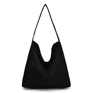 Minimalist black canvas tote bag with wide shoulder strap in a large capacity hobo style