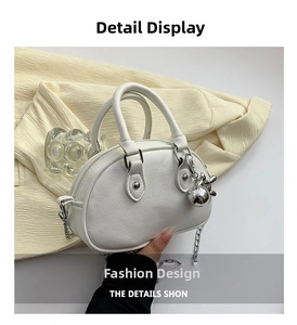 Détail du sac dôme blanc en cuir grainé avec chaîne argentée et pendentif boule