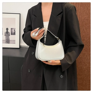 Detail of elegant silver crescent underarm bag with glossy pearlescent finish texture