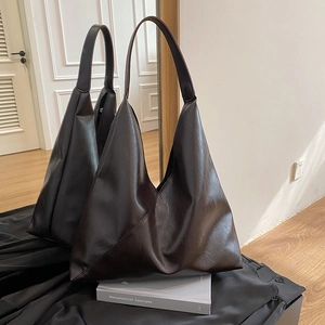 Minimalist large brown tote bag with retro oil wax texture for women in a chic studio setting
