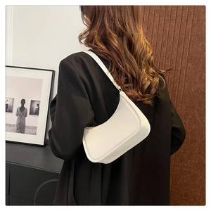 White hobo shoulder bag with lychee texture styled on a model in a black blazer