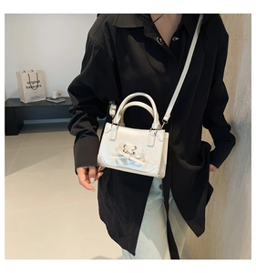 Detail view of cream-white crossbody bag featuring heart cutout and bowknot design