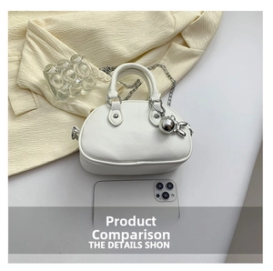 Vue détaillée du sac en cuir texturé blanc avec chaîne argentée et pendentif lapin