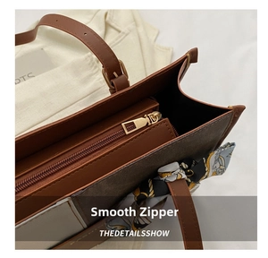 Detail of smooth gold-tone metal zipper and printed canvas on the large tote bag