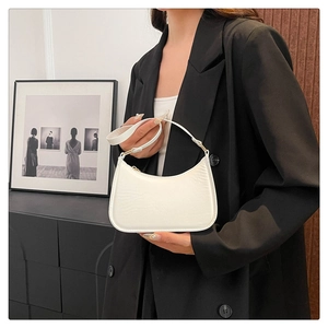 Detail of white minimalist crescent underarm bag with leather texture and metal zipper