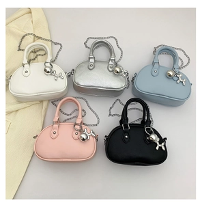 Détails de cinq mini sacs colorés en forme de coquillage avec chaînes et breloques chien ballon