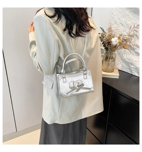 Detailed view of silver metallic mini bag with bow accent worn on person's shoulder