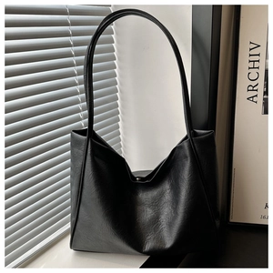 Détails du sac cabas en cuir noir texturé avec une fermeture à boucle magnétique