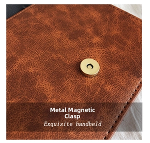 Détail de la boucle magnétique dorée sur un sac à bandoulière en cuir marron vintage