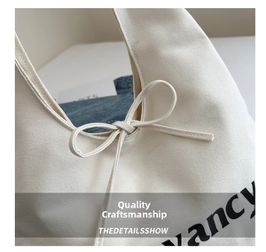 Detail van canvas draagtas met de delicate strik en fancy belettering met textuur