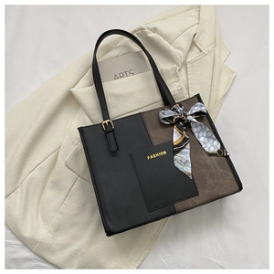 Close-up of contrast color tote bag featuring silk scarf detail and fashion logo