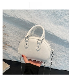 Détail du sac coquillage en cuir grainé blanc avec chaîne argentée et rivets