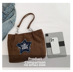 Detail view of brown suede tote bag featuring a blue star patch and metal chain strap