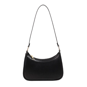 Minimalist black faux leather crescent shoulder bag with golden zipper on white background