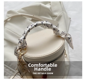 White crocodile pattern cylinder bag with silk scarf wrapped handle and gold hardware