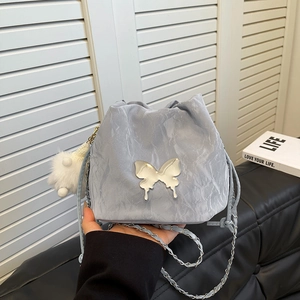 Blue marble bucket bag with silver butterfly buckle and chain strap on hand