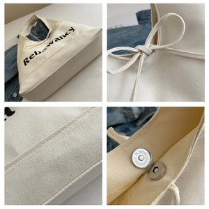 Detail van de witte canvas draagtas met magnetische sluiting en decoratief lint