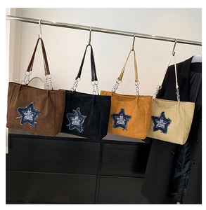 Detailed shot of large suede tote bags in four colors with star patches and chain straps