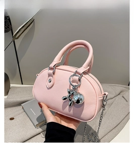 Vue détaillée du sac rose en forme de coquille avec breloque chien ballon argentée