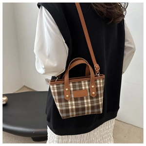 Borsa tote a quadri marrone con manici in pelle e tracolla regolabile su una modella