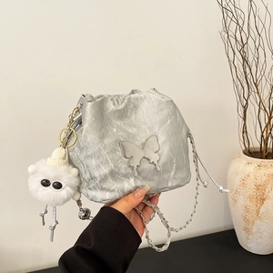 Silver wrinkled bucket bag with metal butterfly and plush charm on chain strap