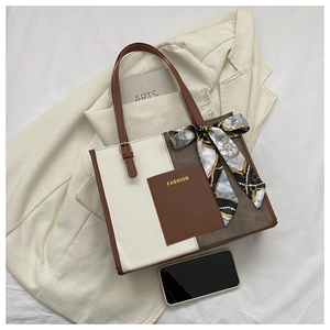 Detail of color-block tote bag with vintage printed scarf on adjustable brown handle