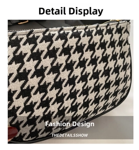 Detail of houndstooth fabric texture with leather piping and gold zipper on a crossbody bag