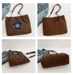 Detail of brown suede tote bag with denim star patch and metal chain strap