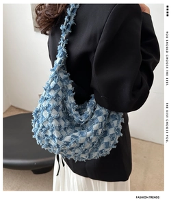 Detail of blue and white checkered denim hobo bag featuring frayed edges and fringe texture