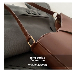 Detail of premium brown leather bag showing gold ring buckle and fine stitching
