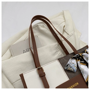 Detail of color-block tote bag featuring printed silk scarf and golden fashion lettering