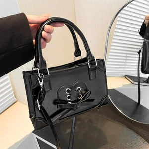 Black patent leather handbag with heart lace-up detail and silver-tone hardware