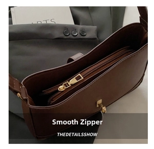 Macro shot of dark brown leather handbag showing golden zipper and internal compartment