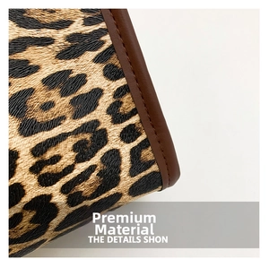 Detail of leopard print fabric with brown leather trim and precision stitching on handbag