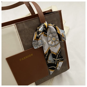 Detail of the canvas and leather patchwork tote bag with a decorative silk scarf