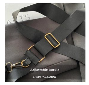 Detail of black woven shoulder strap with adjustable golden metal buckle and swivel hook