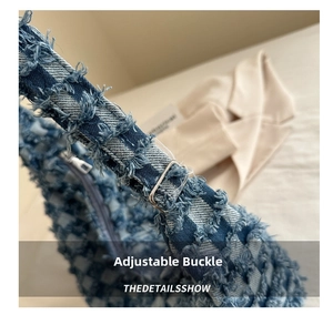 Close-up of blue denim shoulder bag showing adjustable metal buckle and fringe detail