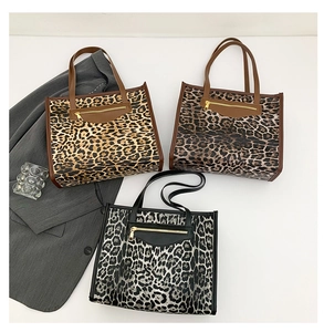 Flat lay of leopard print tote bags in three colors with metallic zipper detail