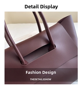 Close-up of premium burgundy leather texture and sturdy handle stitching on tote bag
