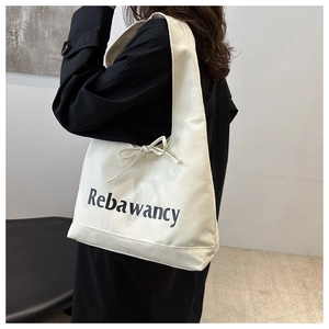 Detail van canvas draagtas met Rebawancy-belettering en een decoratieve strik