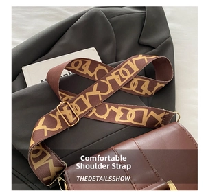 Detail of wide jacquard strap with geometric patterns on dark brown saddle bag