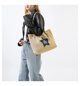 Detail of khaki canvas tote with blue denim star patch and GAKULA logo branding