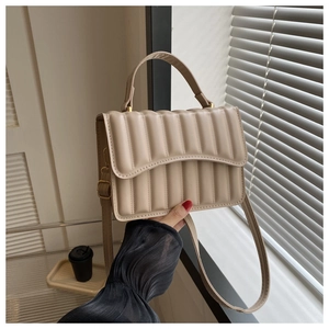 Detail der cremeweißen Stepptasche mit plissierter Bubble-Struktur und Schultergurt